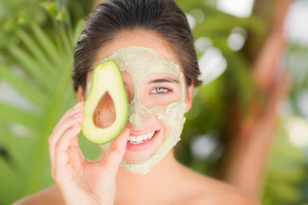 A person holds a natural skincare product near their face, surrounded by lush green foliage, suggesting a tranquil beauty routine.