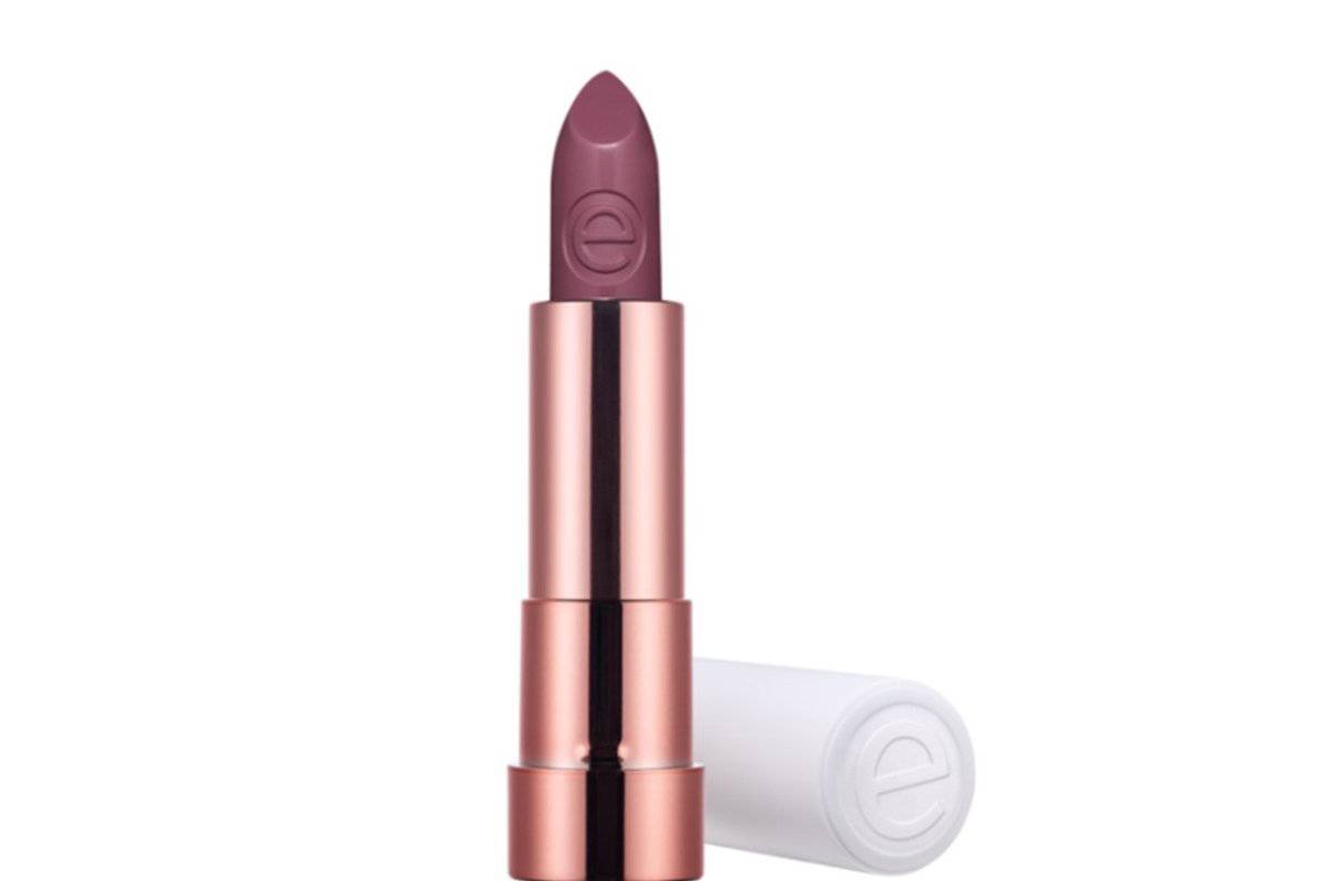 A close-up of a sleek, rose gold lipstick tube with a deep purple shade, partially opened, showcasing its creamy texture.