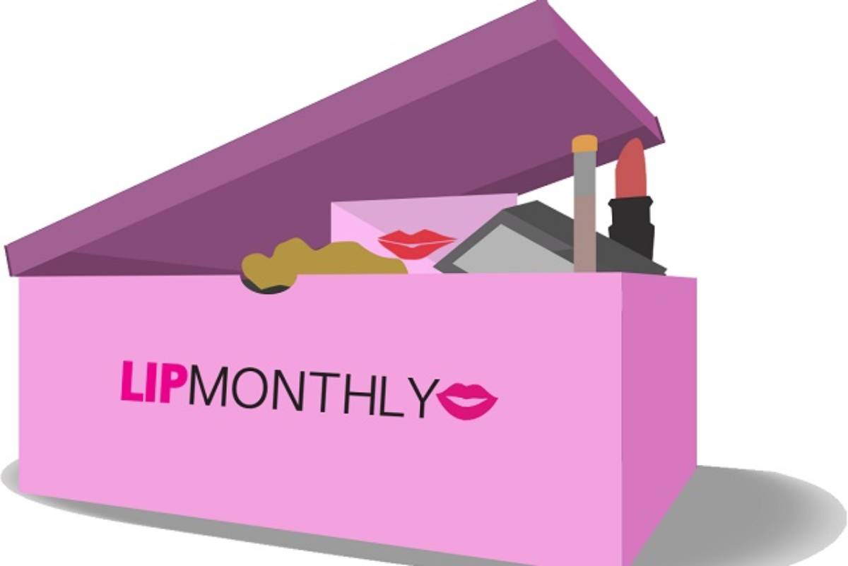 A pink open box labeled LIPMONTHLY showcasing various cosmetics, including lipstick, lip gloss, and makeup items inside.