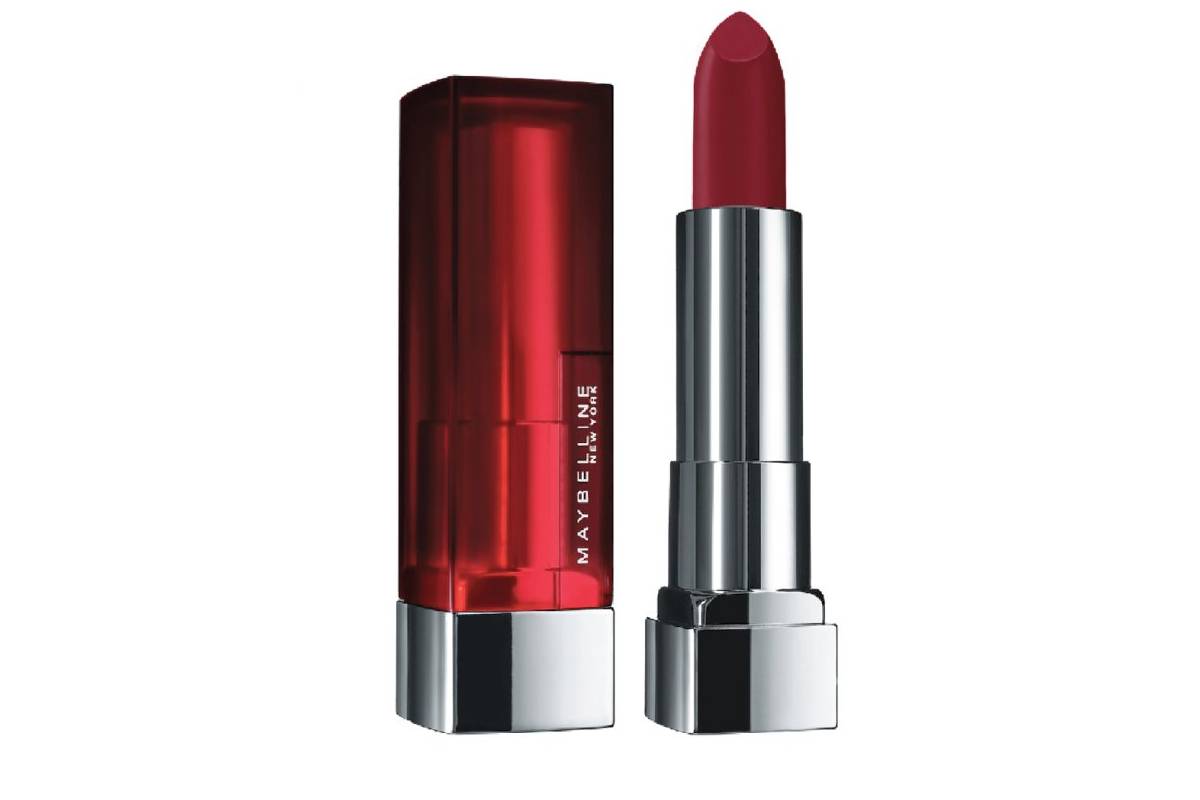 Maybelline lipstick in a bold red shade, displayed upright with its glossy red and silver packaging beside it.
