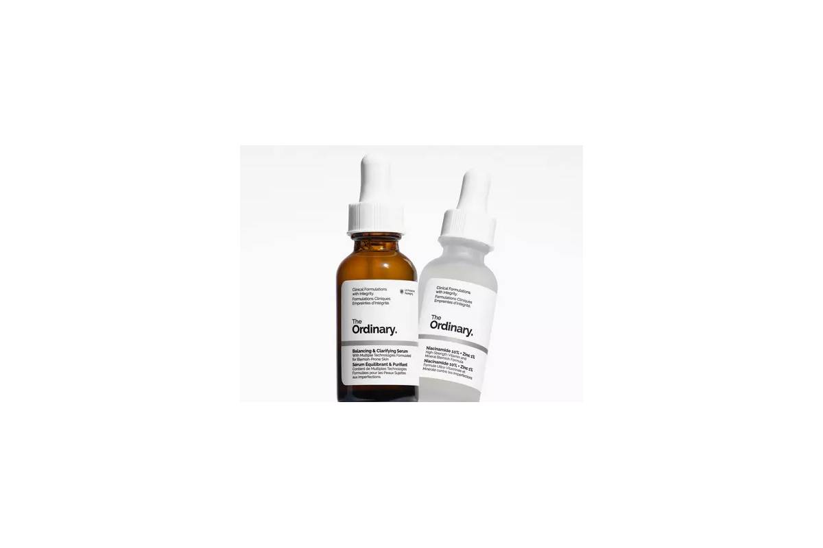Two bottles of The Ordinary skincare serums; a brown glass bottle and a white plastic bottle, both with droppers.