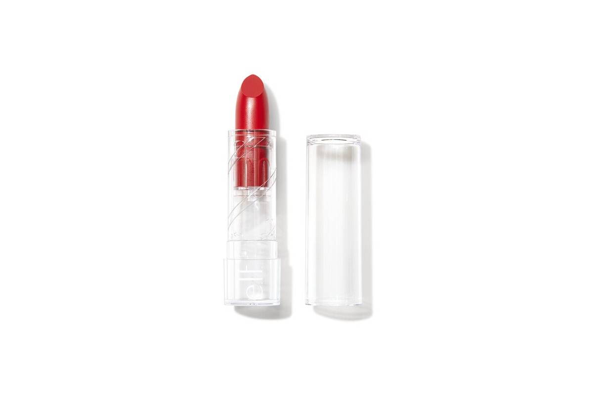 A bright red lipstick in a clear tube, partially opened with the cap beside it, showcasing its vibrant shade.